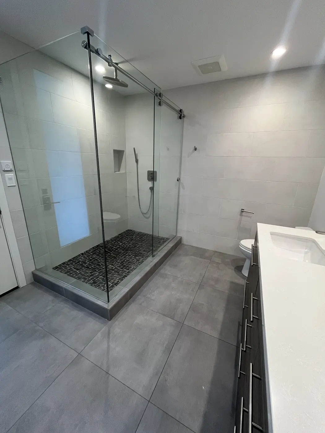 Custom glass walk-in shower with modern tile