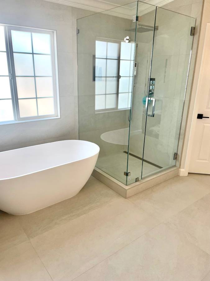 Bright bathroom remodel with a frameless glass shower and freestanding tub