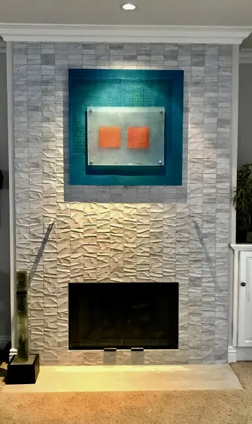 Floor-to-ceiling stacked stone fireplace feature wall with recessed artwork and accent lighting