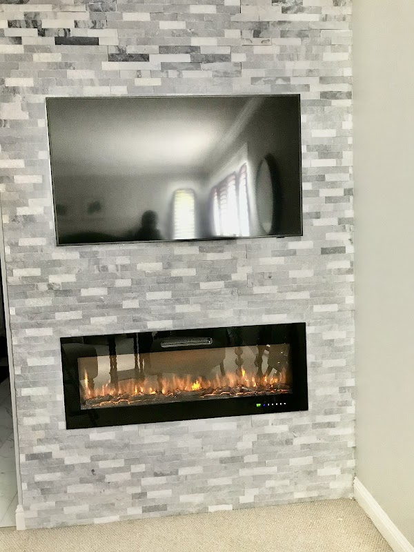 Floor-to-ceiling stacked stone tile fireplace surround